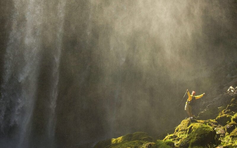 Person Standing on Mossy Rock