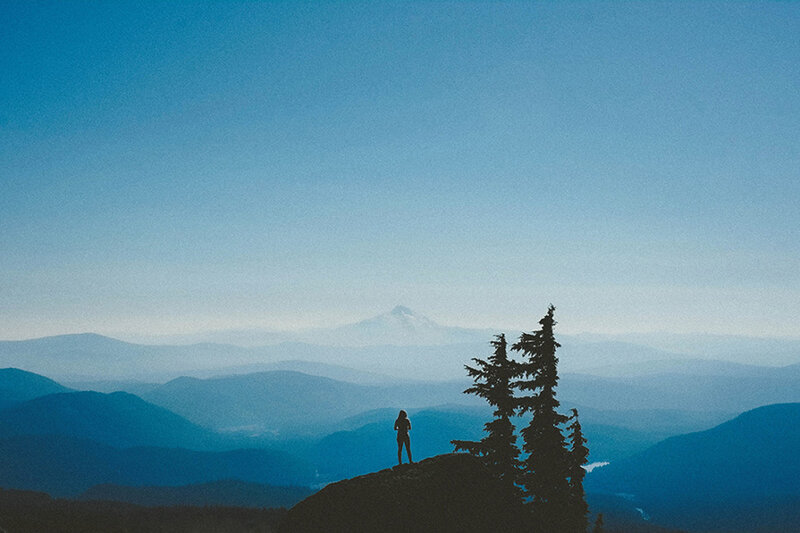 Person Standing on Mountain — Blue
