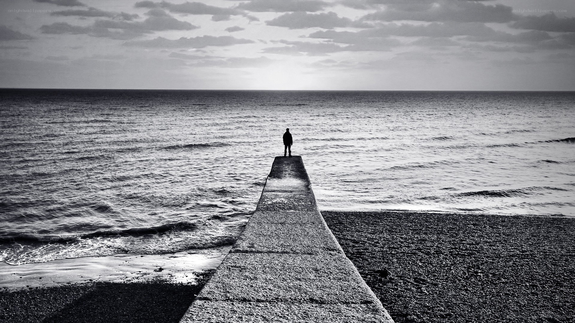 person standing on pier at sea