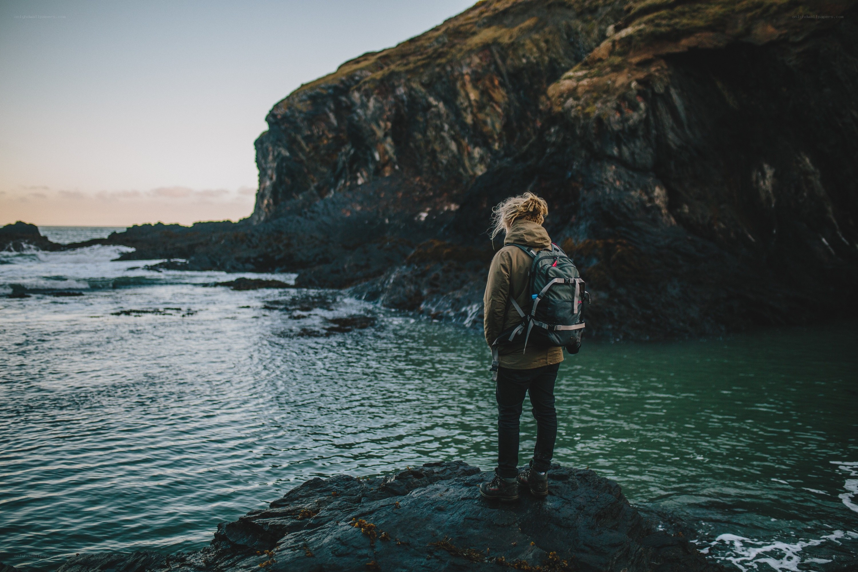 person standing on rocky shore