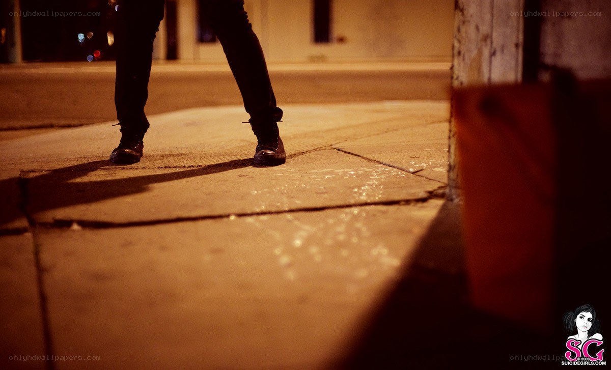 person standing on sidewalk at night