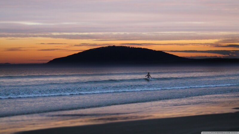 Person Surfing at Sunset