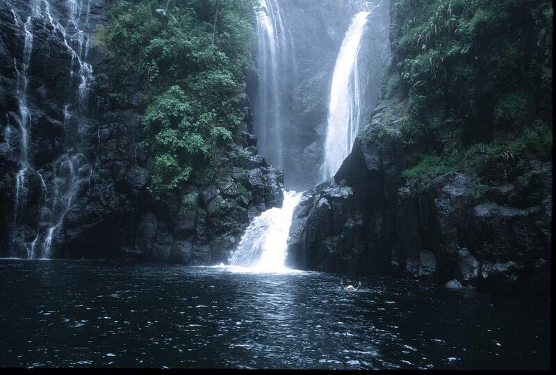 Person Swimming under Waterfall