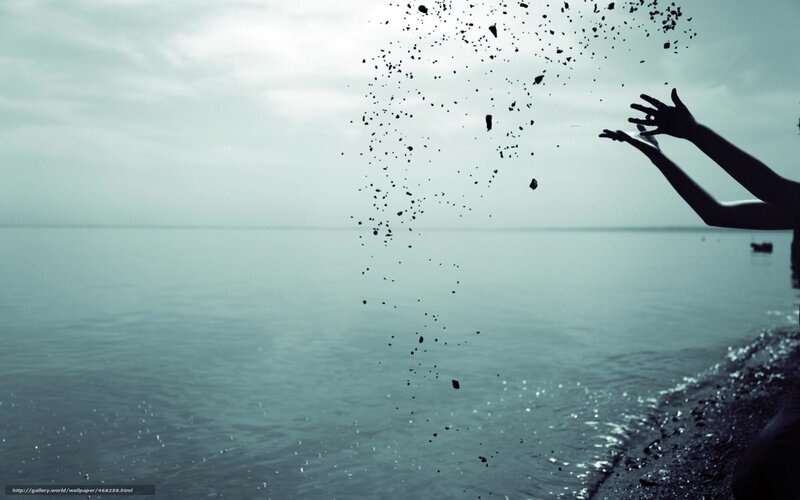 person throwing pebbles at the sea