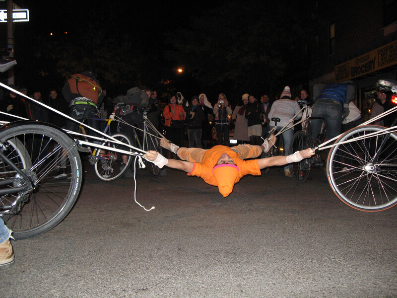 person tied between bicycles