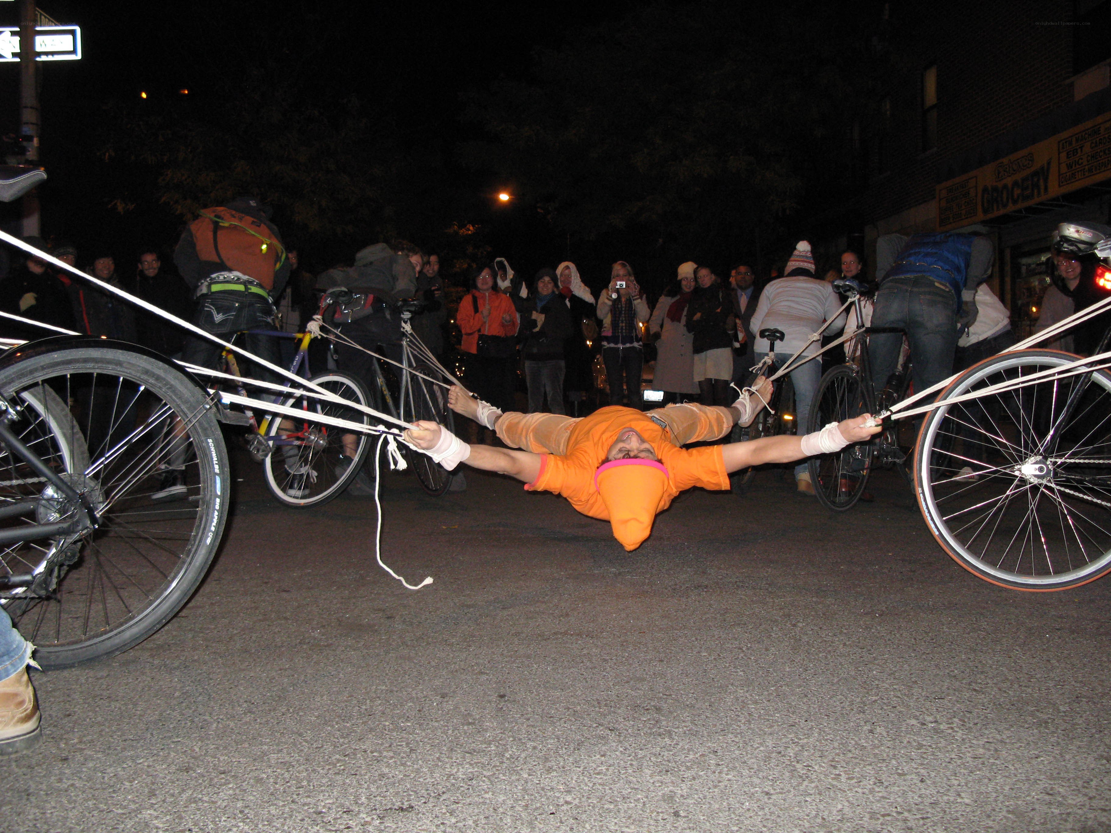 person tied between bicycles