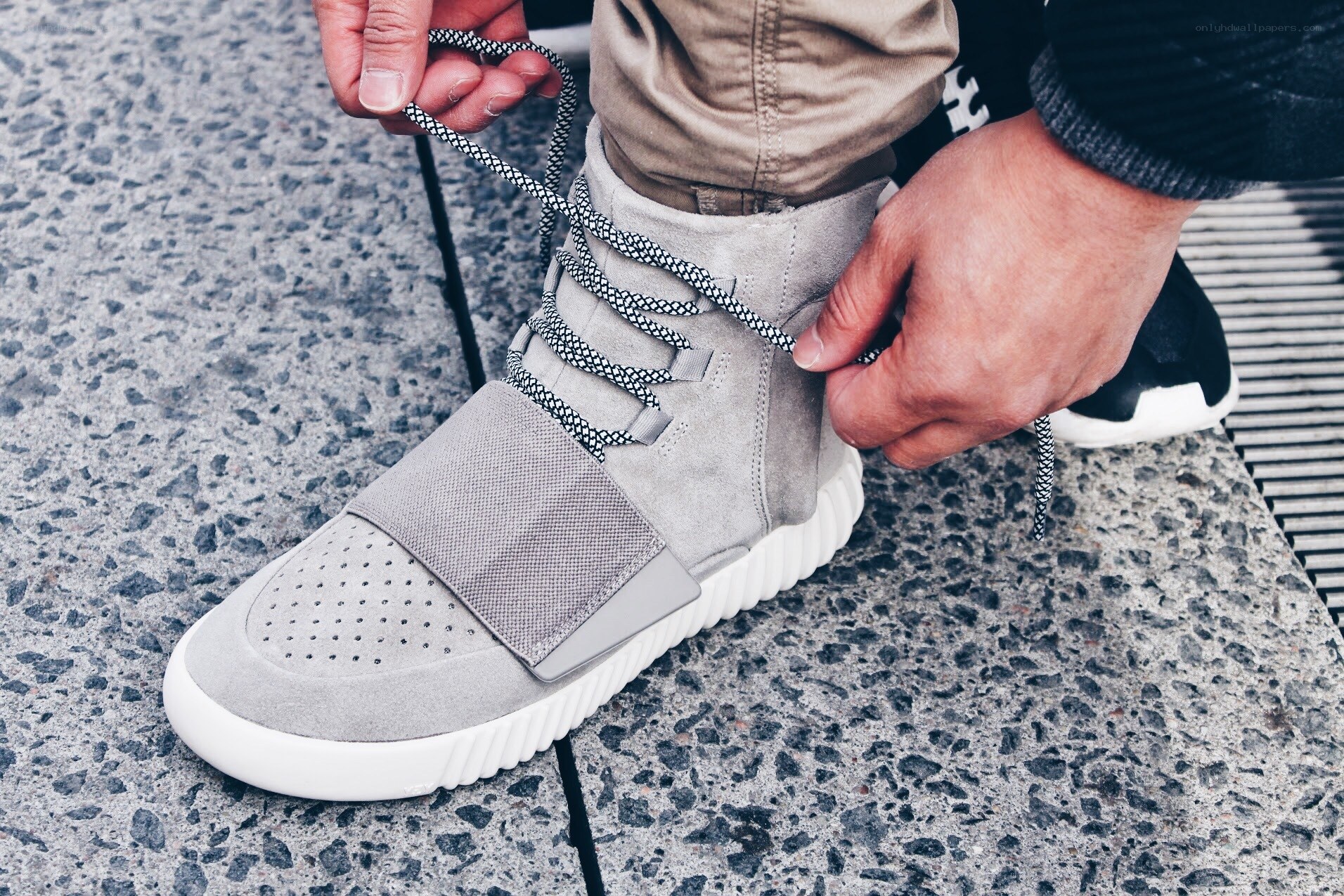 person tying gray sneakers