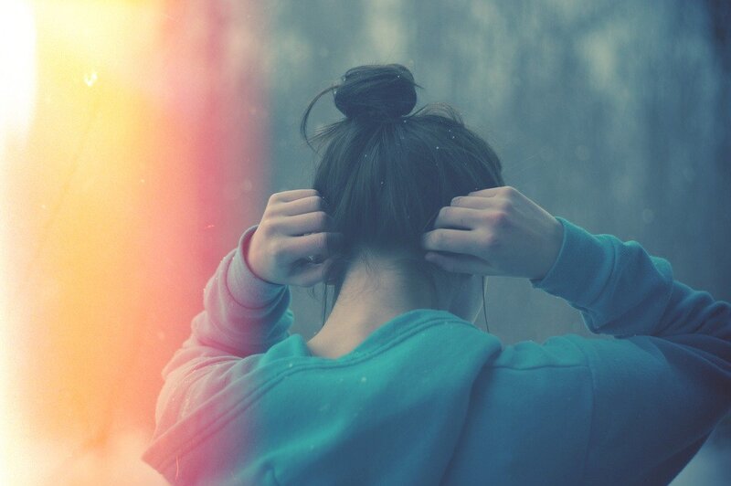 person tying hair in a bun