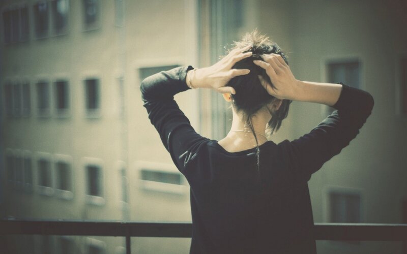 person tying hair on balcony