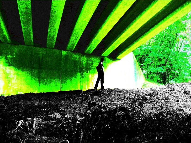 Person under a bridge at night