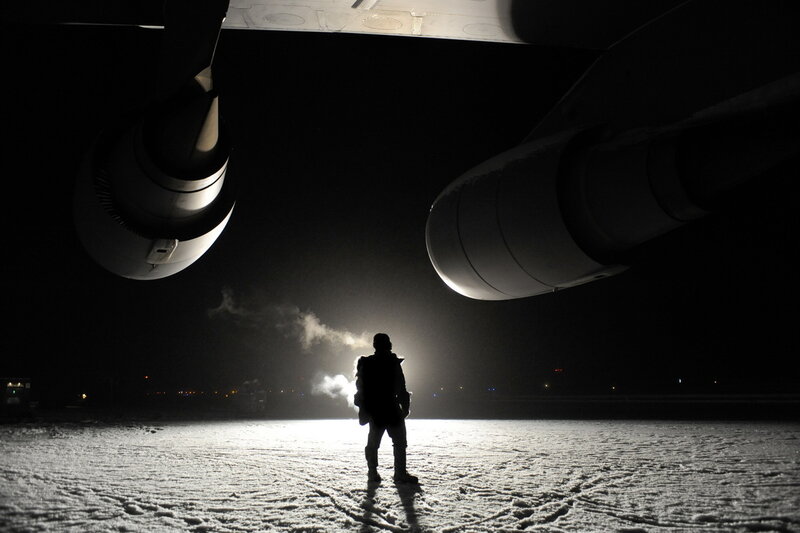 Person under airplane at night
