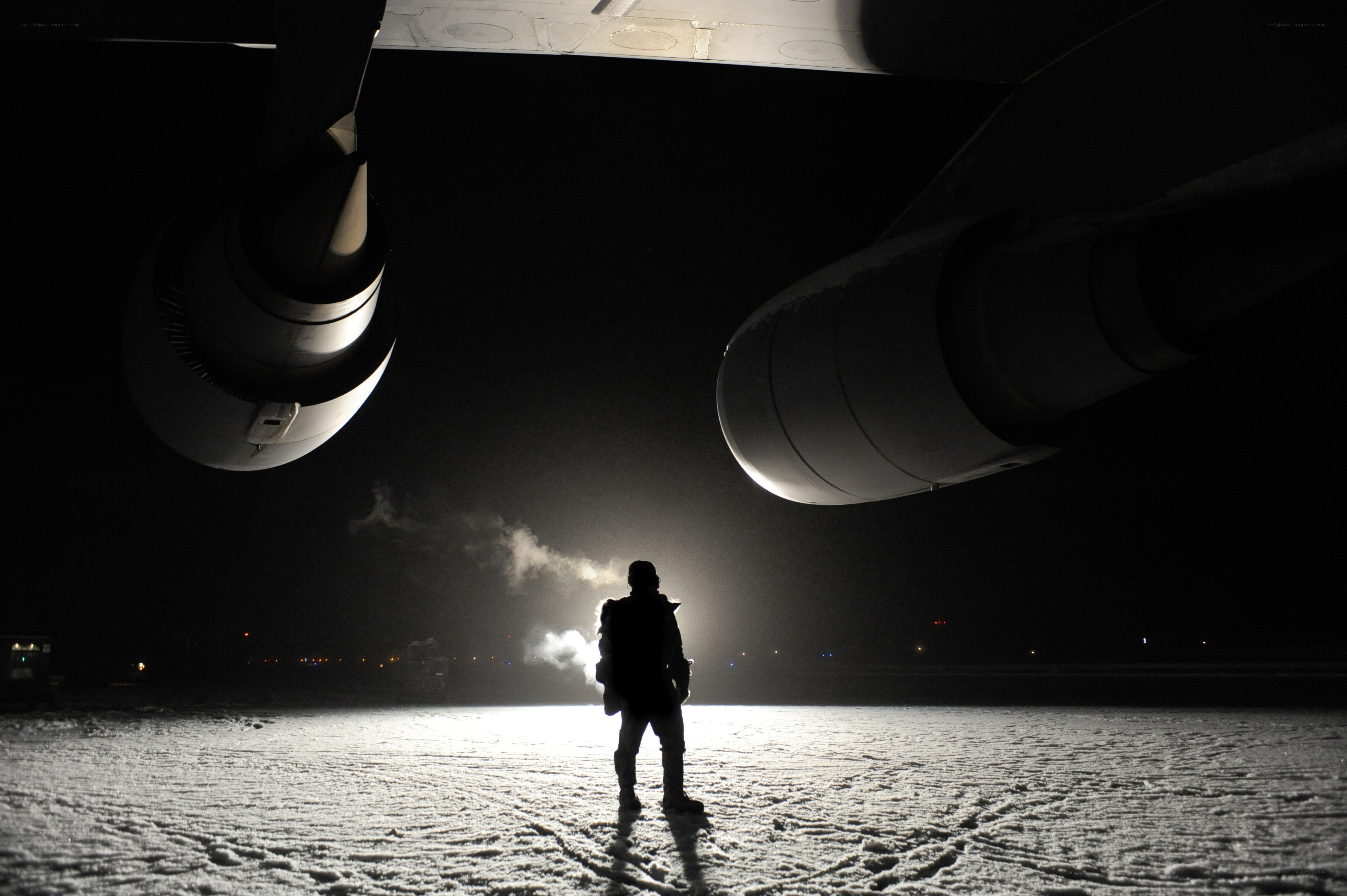 Person under airplane at night