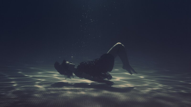 person underwater in pool