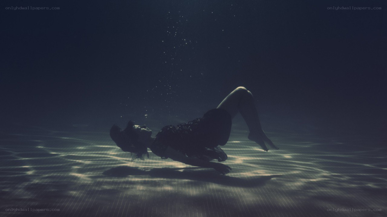 person underwater in pool