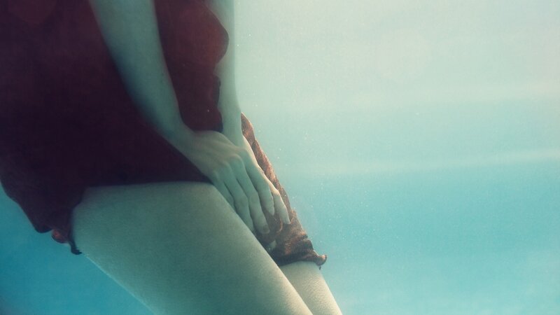 person underwater in red garment