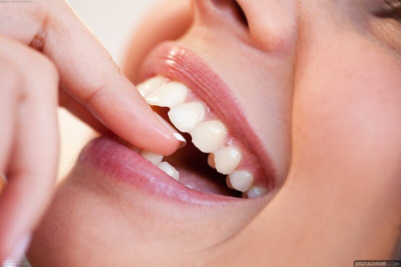person using finger to clean teeth