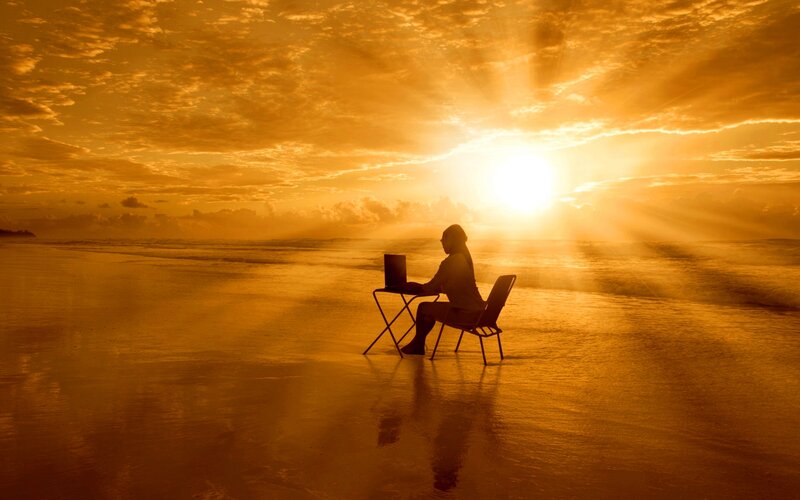 Person Using Laptop on Beach