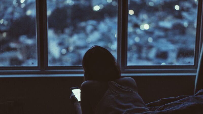 person using phone by window