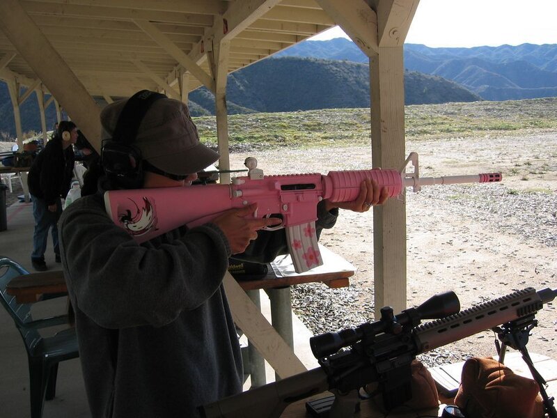 person using pink rifle at range