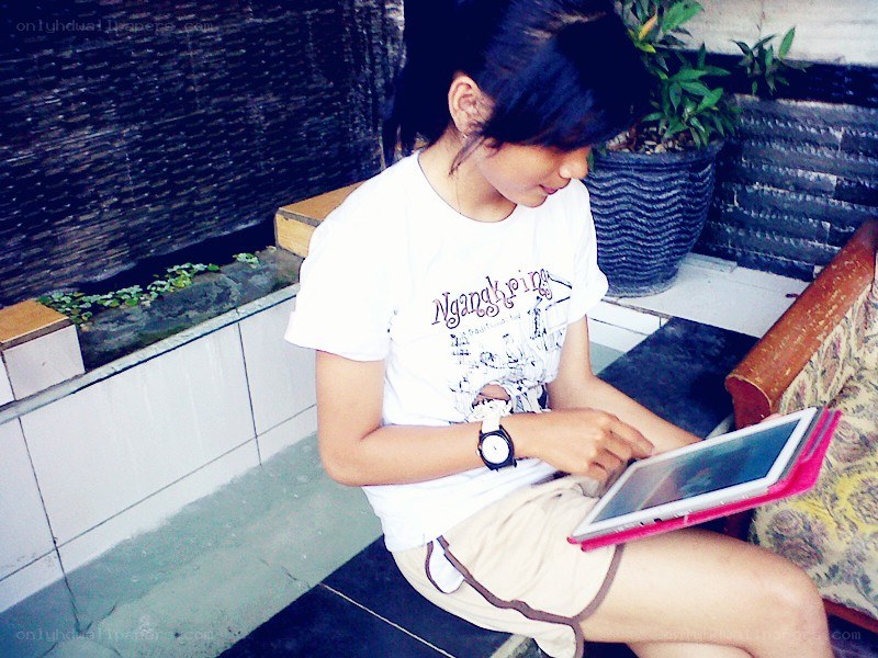 person using tablet on bench