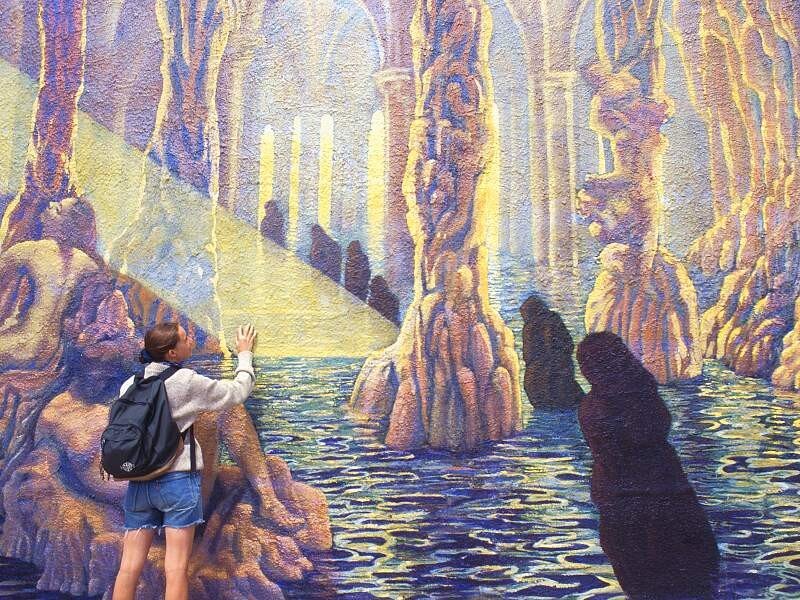person viewing cave mural