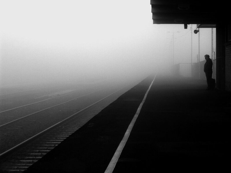 Person waiting on foggy train platform