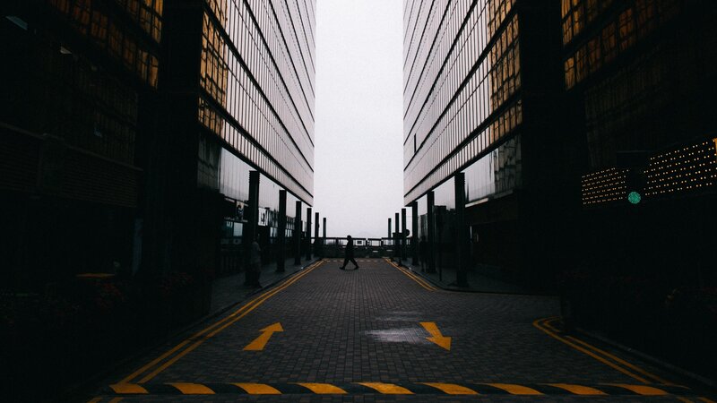 Person Walking Between Buildings