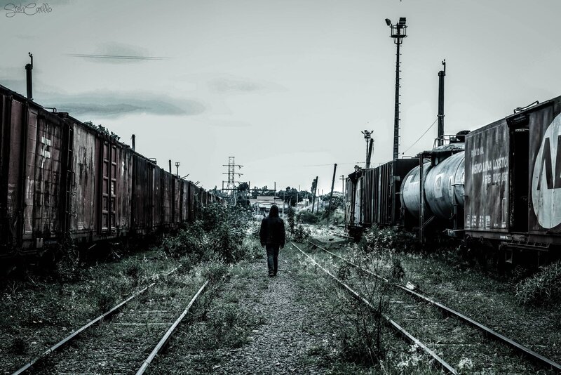 Person Walking Between Trains