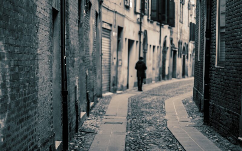 person walking down a narrow alley