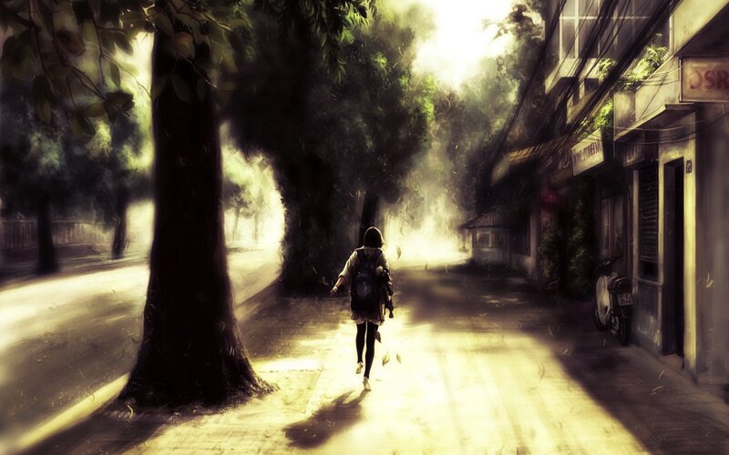 person walking down a sunlit street