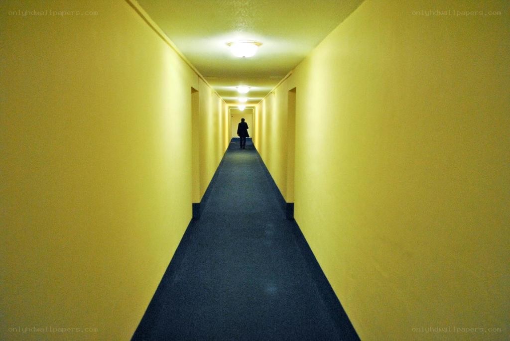 person walking down a yellow hallway