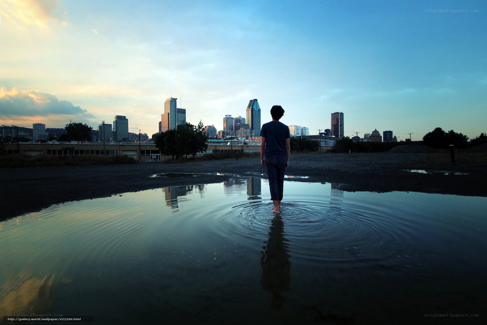 Person walking in puddle at sunset