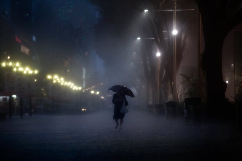 Person walking in rain at night