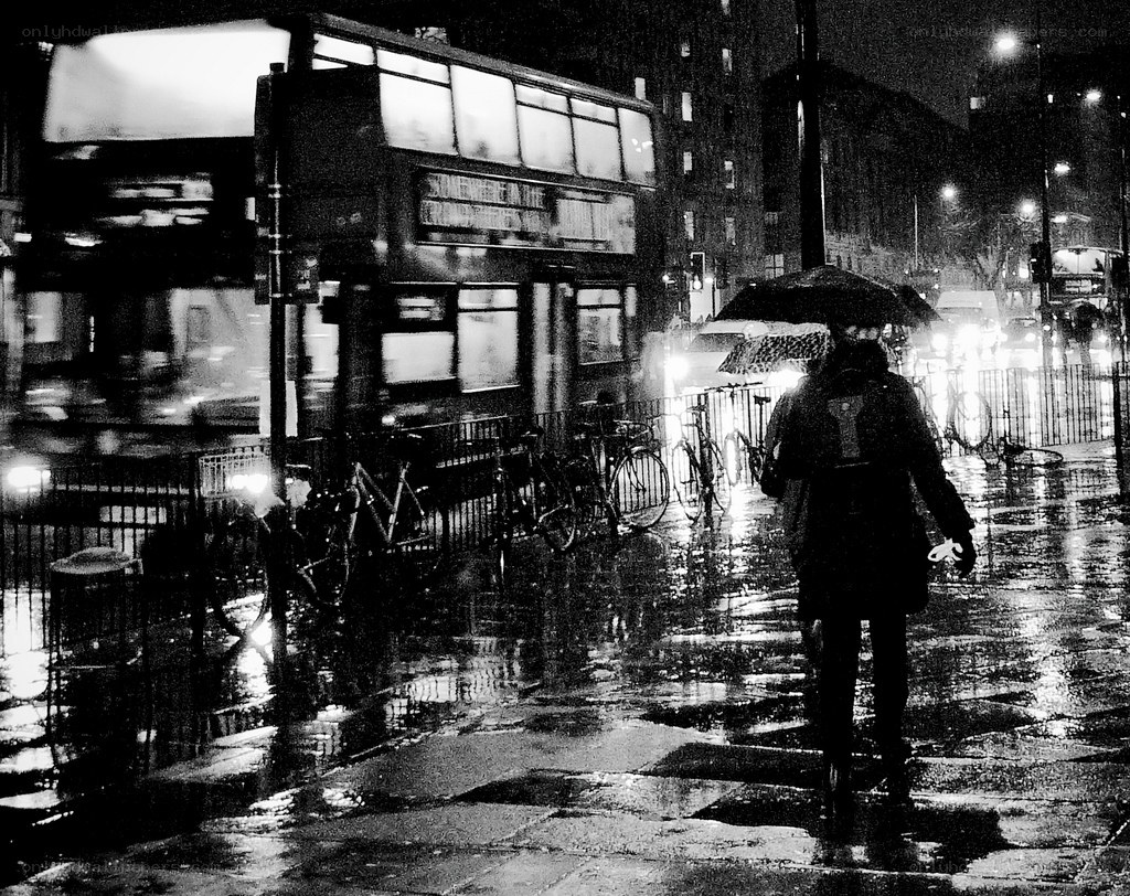 person walking in rain at night