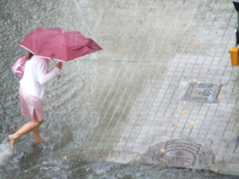 person walking in rain with umbrella