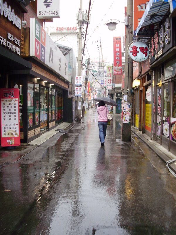person walking in rainy alley
