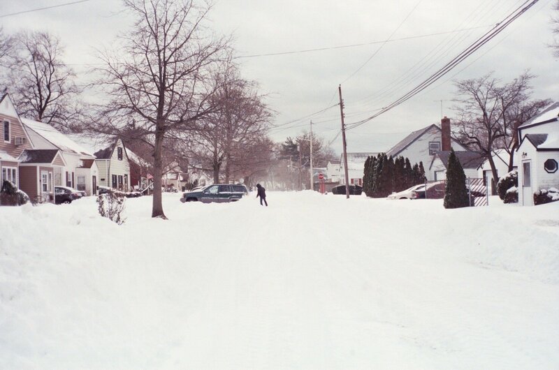 Person Walking in Snow — White, Cold, Winter, Photograph, Houses