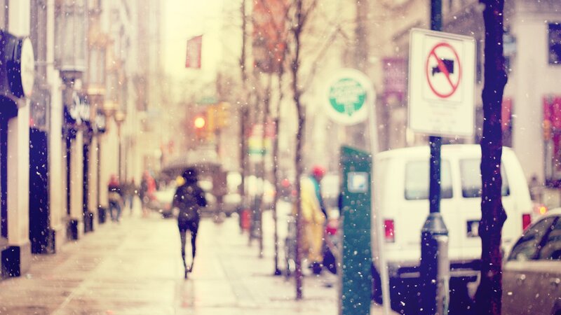 person walking in snowy city