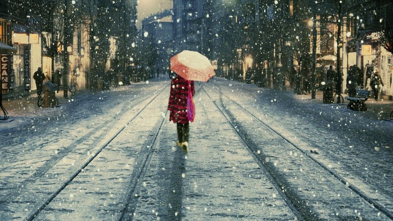 person walking in snowy city