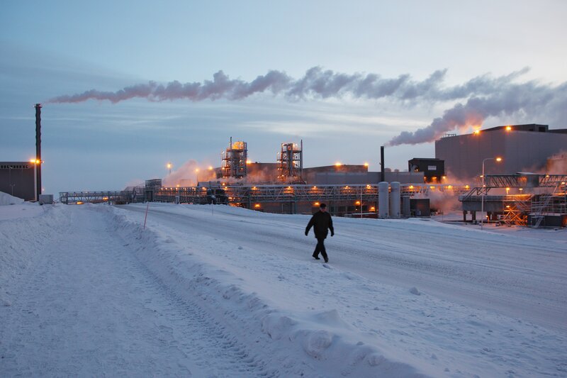 Person walking near industrial plant