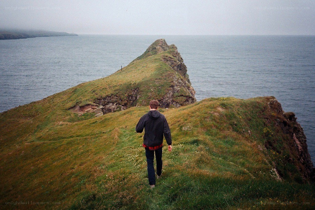 person walking on a coastal cliff
