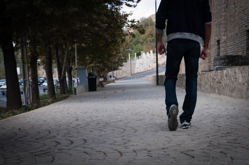 person walking on a cobblestone path