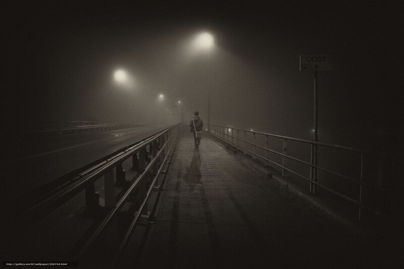 Person walking on a foggy bridge