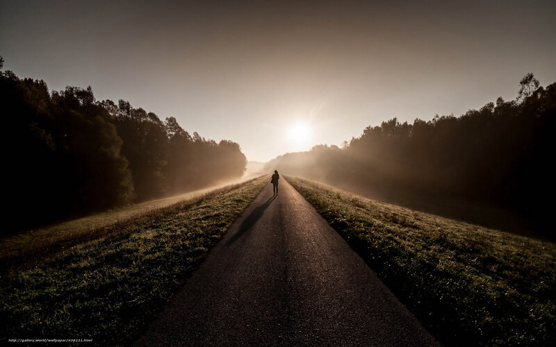 Person walking on a road at sunrise