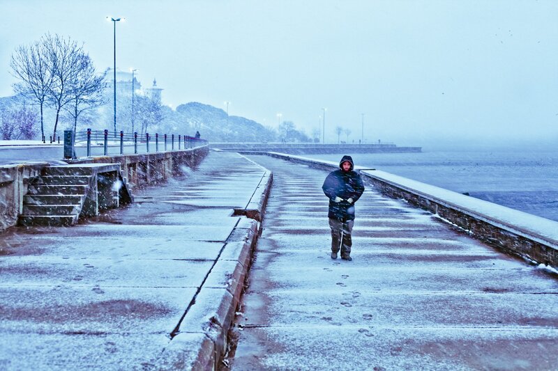 Person walking on a snowy pier