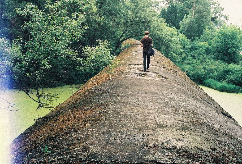 Person walking on a stone bridge