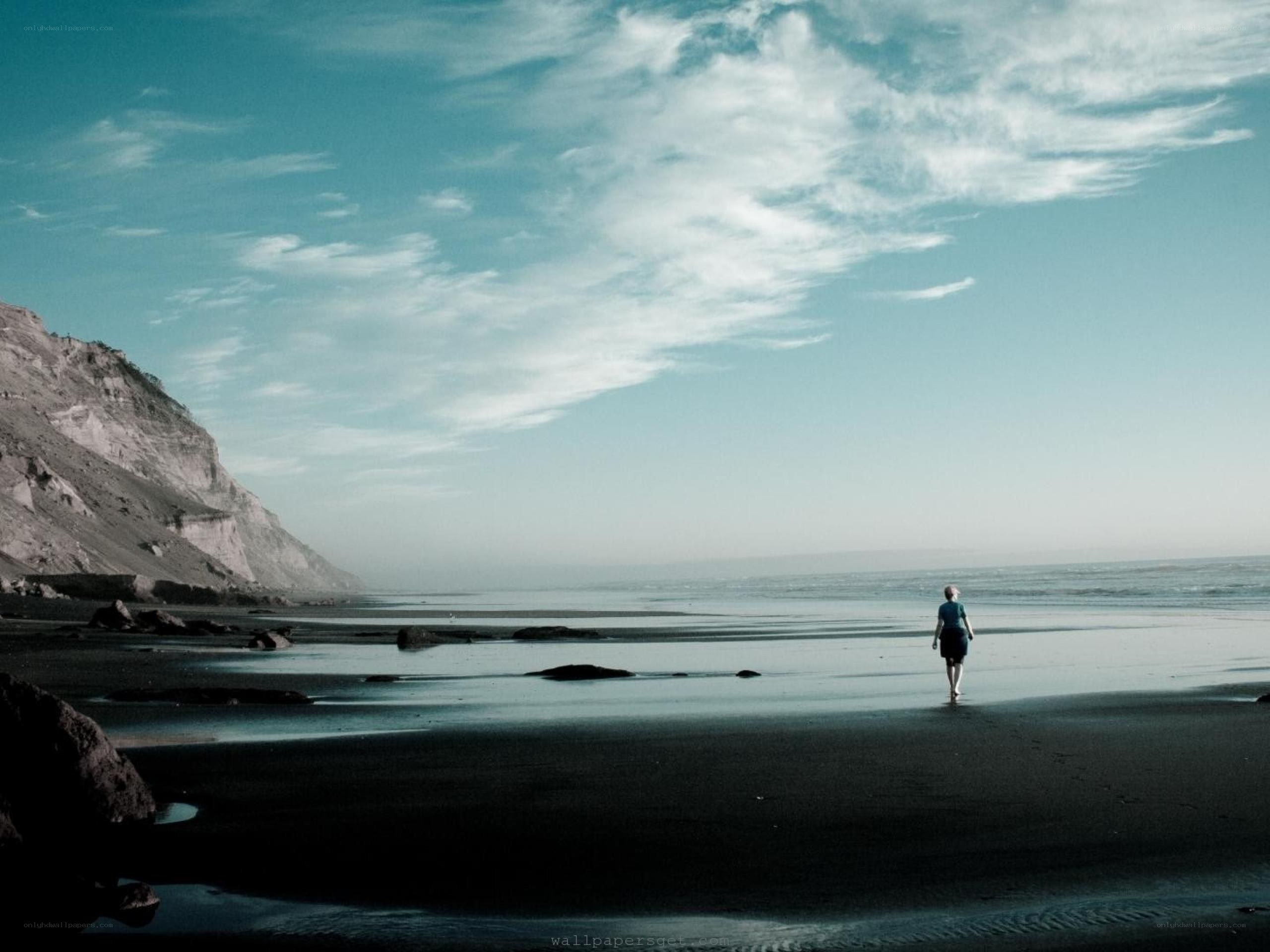 Person walking on beach at dusk