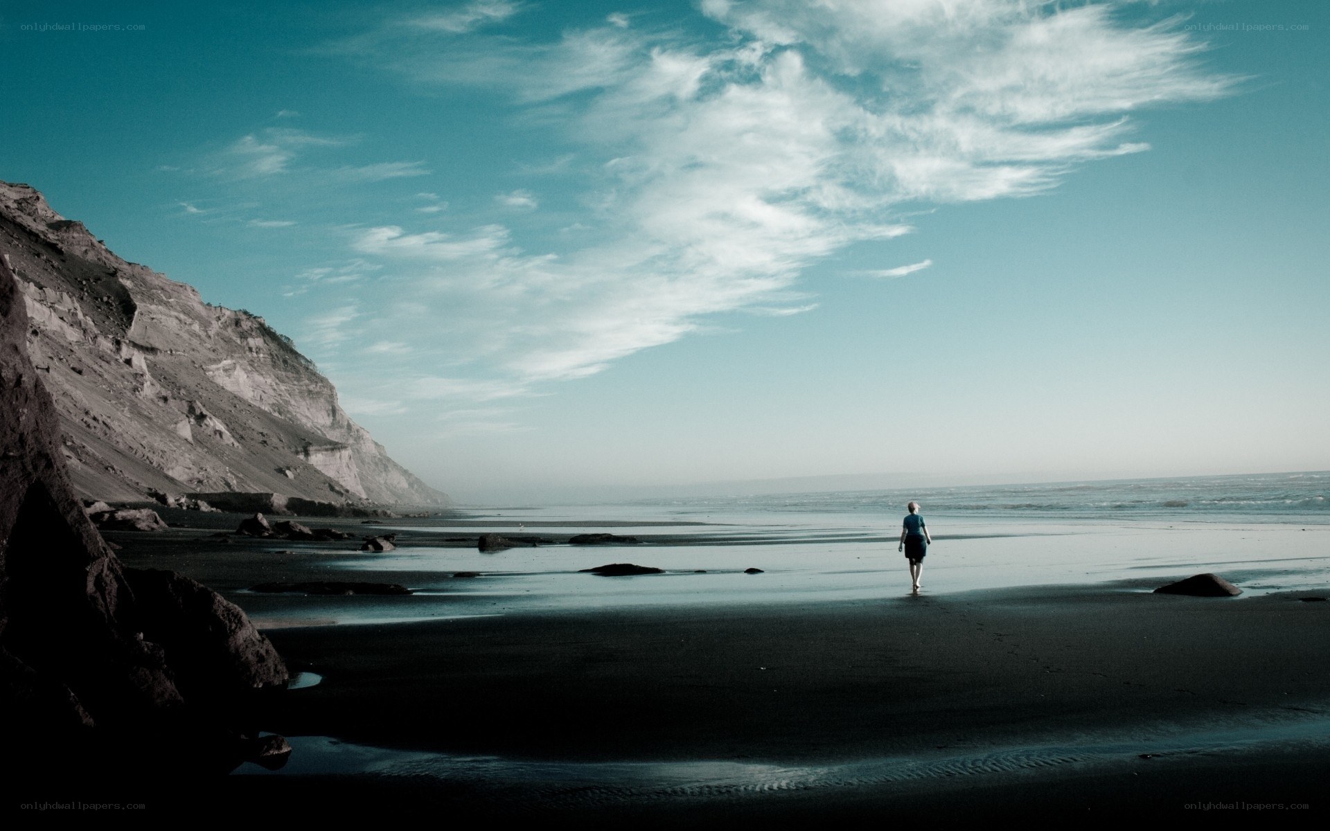 Person walking on beach at dusk