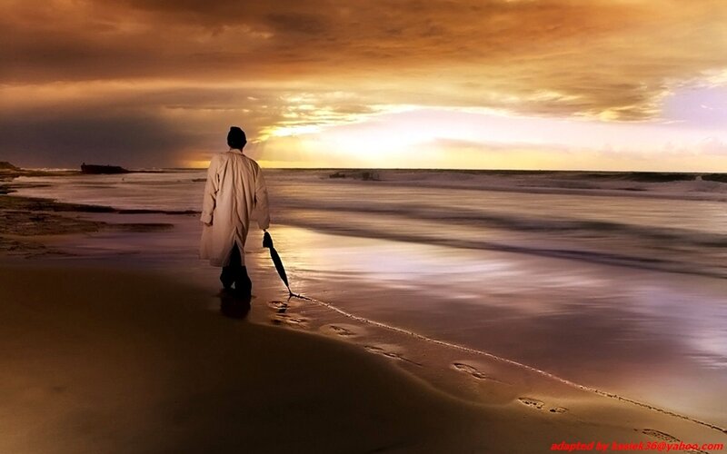 Person walking on beach at sunset