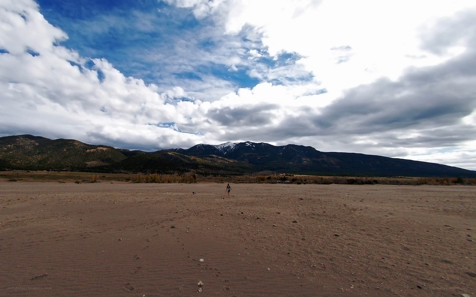 person walking on dry riverbed
